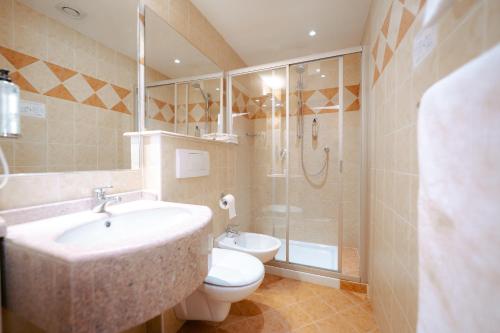 a bathroom with a sink and a toilet and a shower at Hotel Everest in Trento