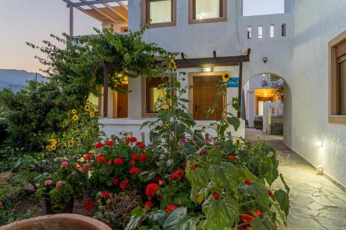 a garden with flowers in front of a building at Akrotiri Apartments in Makry Gialos