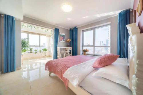 a bedroom with a bed with a red and white bedspread at Cloud & Sea Boutique Apartment in Rizhao