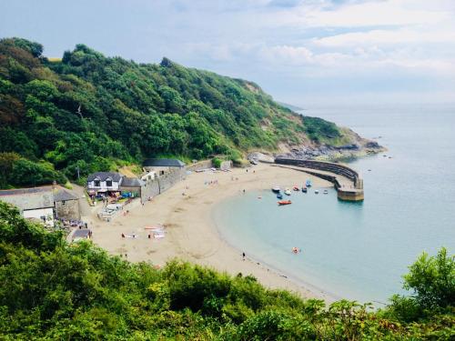a beach with people in the water and a bridge at The Coach House in Par