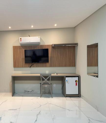 a room with a desk with a tv and a desk at Hotel Radan in Luis Eduardo Magalhaes
