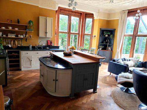 a kitchen with an island in the middle of a room at 3 bedroom 3 bathroom ground floor condo with veranda in Reigate