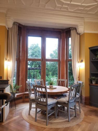 a dining room with a table and chairs in front of a window at 3 bedroom 3 bathroom ground floor condo with veranda in Reigate