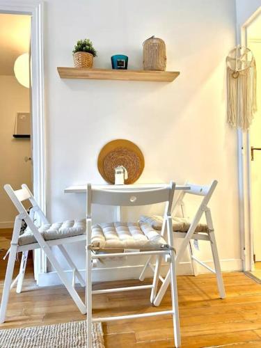 une table et deux chaises dans une pièce dans l'établissement La perle Bleue - appartement cosy à La Défense, à Puteaux
