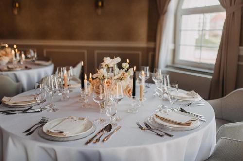 a white table with plates and glasses on it at Hotel Piast in Opole