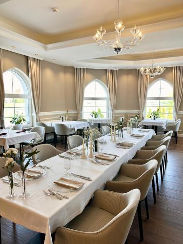 a dining room with a long table and chairs at Hotel Piast in Opole