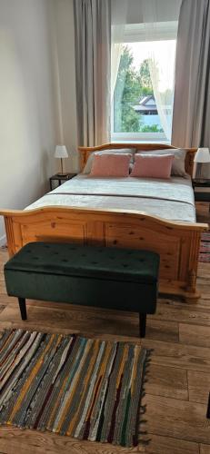 a wooden bed with a green ottoman in a bedroom at Lipowy Kąt in Gołdap