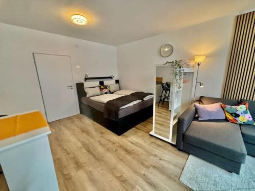 a bedroom with a bed and a couch and a mirror at Auszeit am Rhein 1 - Rhinelove in Boppard