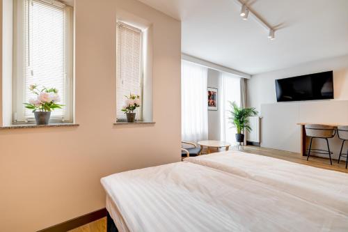 a bedroom with two beds and two windows at King Apartamenty Galaxy in Szczecin