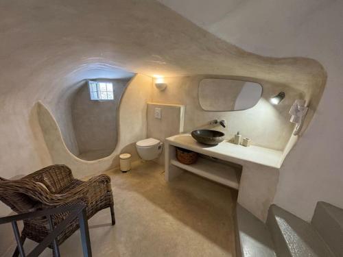 ein Badezimmer mit Waschbecken und Toilette in einem Zimmer in der Unterkunft Pano Meria Venetian Style Studio I in Oia