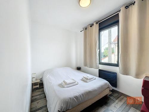 a bedroom with a bed and a window at Le Petit Loft in Wimille