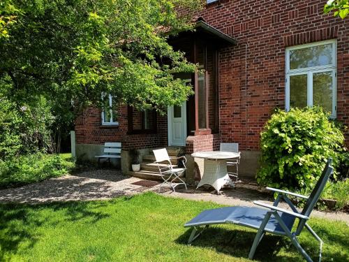 una casa de ladrillo con una mesa y sillas en el patio en Norby Garden Westwärts, en Rieseby