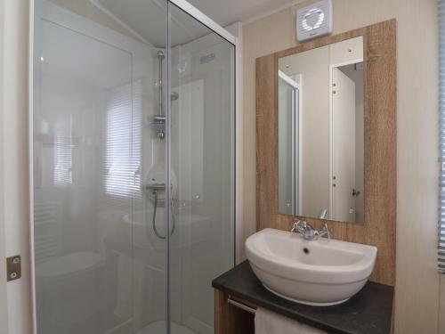 a bathroom with a sink and a glass shower at Tri-Star House in Charmouth