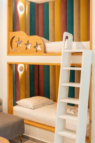 a bunk bed with a ladder in a room at Luna Mare Boutique Seaside in Borsh