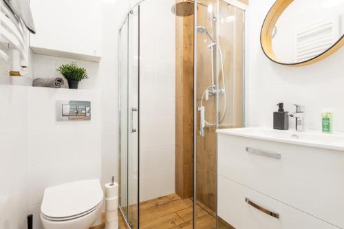 a bathroom with a shower and a toilet and a sink at SuperApart Zdobnicza 4 in Warsaw