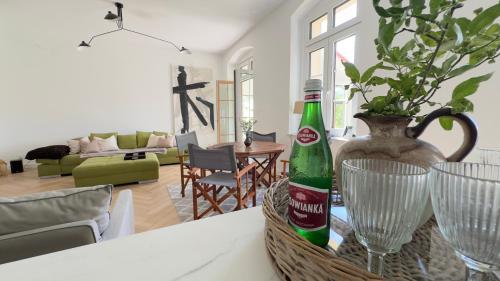a room with a table with two bottles and a vase at Harmonia Appartements Lagow in Łagów