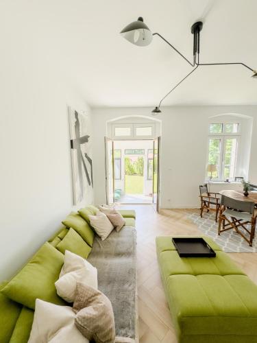 a living room with a green couch and a table at Harmonia Appartements Lagow in Łagów