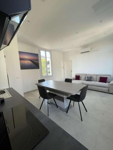 un salon avec une table, des chaises et un canapé dans l'établissement Cosy flat 250m from beach, à Nice
