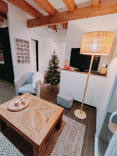 un salon avec une table et un sapin de Noël dans l'établissement le chalet du bout du lac, à Gérardmer