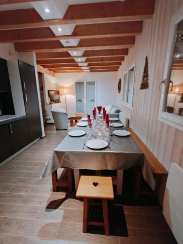 - une salle à manger avec une longue table et des verres dans l'établissement le chalet du bout du lac, à Gérardmer