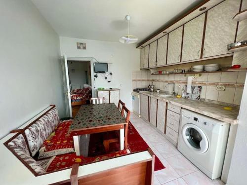 een keuken met een tafel en een wasmachine bij Marin DenizeR Tatilevi in Amasra