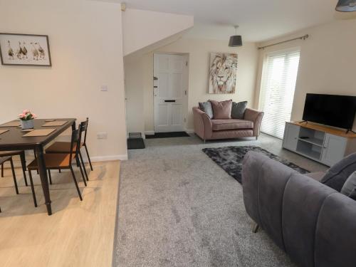 a living room with a table and a dining room at The Stocks in Newton-le-Willows
