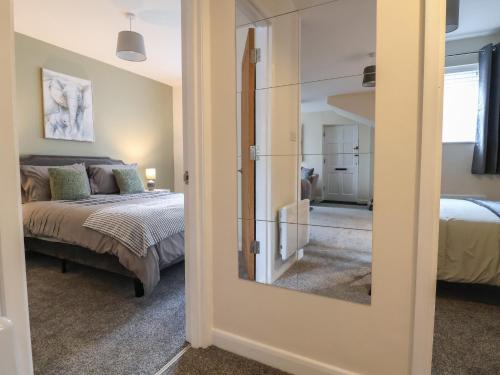 a room with a bedroom with a bed and a mirror at The Stocks in Newton-le-Willows