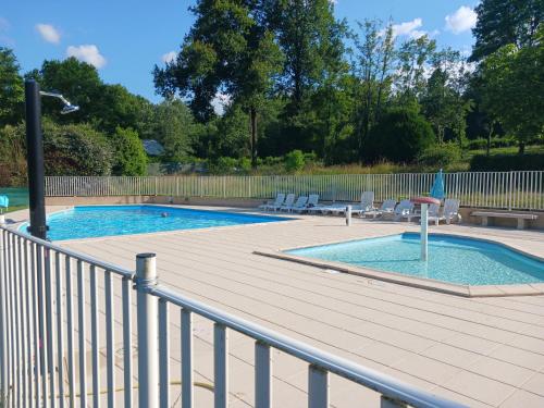 une piscine avec une terrasse et une clôture dans l'établissement Mobil'home, à Thiviers