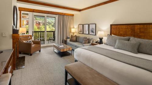 a bedroom with a large bed and a living room at 309 VILLAGE GREEN By Stowe Mountain Rentals in Stowe