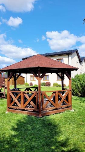 a wooden gazebo with a roof on the grass at Gościniec Krys in Żnin