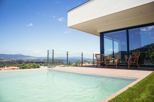 a swimming pool in the backyard of a house at Villa Amores Riverview - Your Scenic Getaway - uChill in Vila Nova de Cerveira