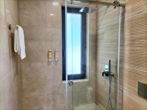 a bathroom with a shower with a glass door at Villa Amores Riverview - Your Scenic Getaway - uChill in Vila Nova de Cerveira