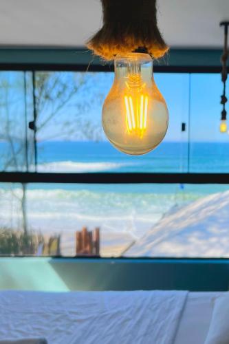a light bulb hanging in front of a window at Graffi Beach House in Florianópolis