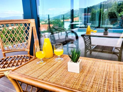 a table with two glasses of orange juice on it at Villa Amores Riverview - Your Scenic Getaway - uChill in Vila Nova de Cerveira