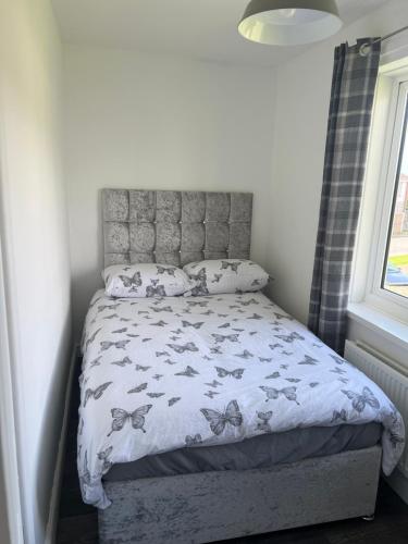 a bedroom with a bed with a butterfly comforter at Cherry Blossom in Pembrokeshire
