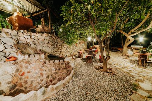 a garden with a tree and a stone wall at Hotel Vallehermoso in Cotahuasi