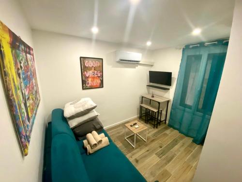a living room with a blue couch and a television at Villa Heritage in Beausoleil
