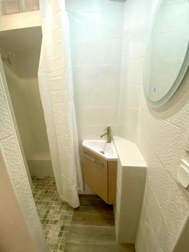 a white bathroom with a sink and a mirror at Villa Heritage in Beausoleil