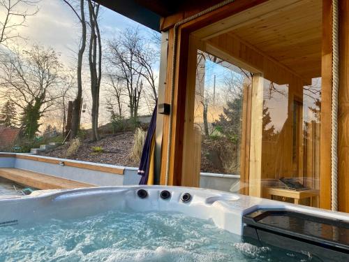 a hot tub in a house with a window at Zebikuckó vendégház in Zebegény