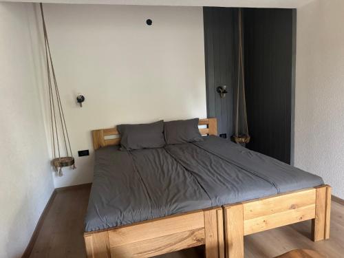 a bed with a wooden frame in a bedroom at Vila Aspen - Mountain View Apartments in Delčevo