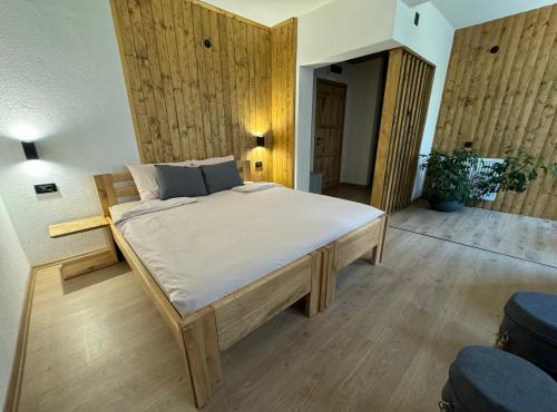 a large bed in a room with wooden walls at Vila Aspen - Mountain View Apartments in Delčevo