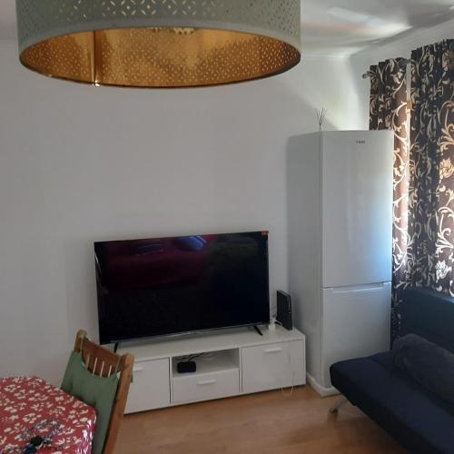 a living room with a flat screen tv on a white cabinet at Ranjeet felizarda in Lisbon
