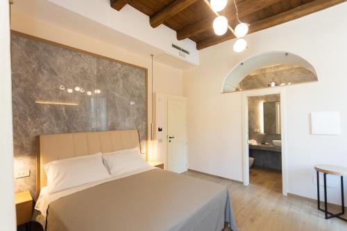 une chambre avec un lit et une grande fenêtre dans l'établissement Heraklean Suites Tropea, à Tropea