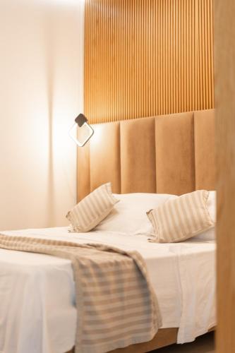 a bed with two pillows and a lamp on it at Luna Mare Boutique Seaside in Borsh