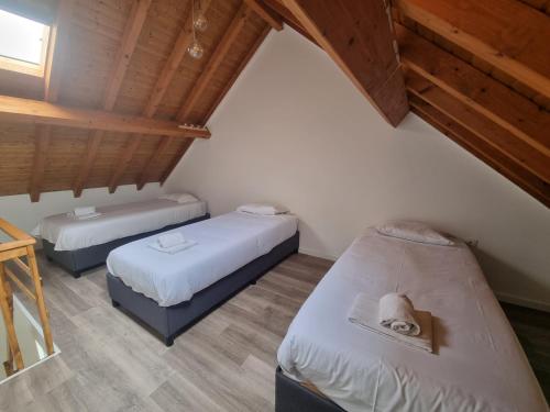 two beds in a room with wooden ceilings at G3 Gamboa Beach Houses in Peniche