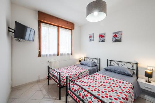 a bedroom with two beds and a tv in it at B3- Le Magnolie vicino a Bologna Fiera, Lugo Hospital Villa Maria, Ravenna in SantʼAgata sul Santerno