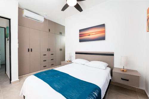 a bedroom with a white bed and a ceiling fan at Depa Familiar PB 6pax con Alberca Rodeado de Restaurantes Zona Segura in Playa del Carmen