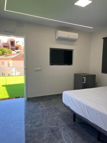 a bedroom with a bed and a flat screen tv at Villa Amir in Fuengirola