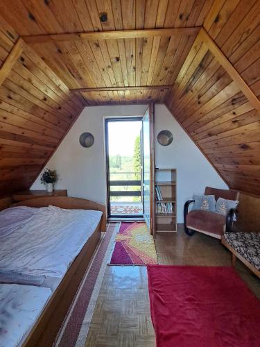 a bedroom with a large bed in a wooden ceiling at Chata u lesa in Medlovice