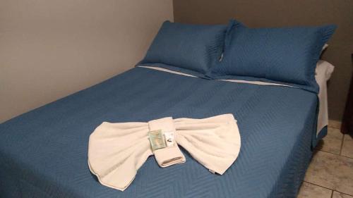a blue bed with a bow tie on it at Alliance Hotel in Bauru